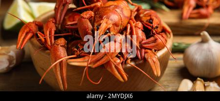Delicious red boiled crayfishes on table, closeup. Banner design Stock Photo