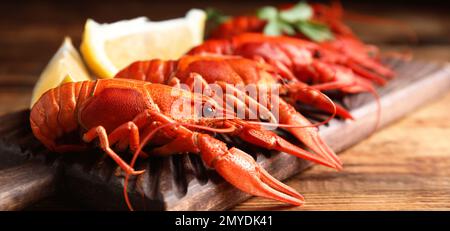 Delicious red boiled crayfishes on table, closeup. Banner design Stock Photo