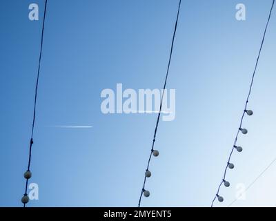 Decorative illumination for the new year in the city. A chain of light bulbs against the sky. Cozy place. Yard decoration Stock Photo