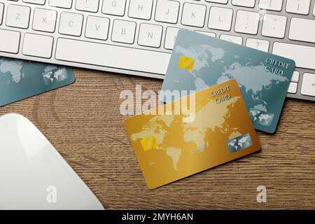 Credit cards, computer keyboard and mouse on wooden background, flat lay Stock Photo