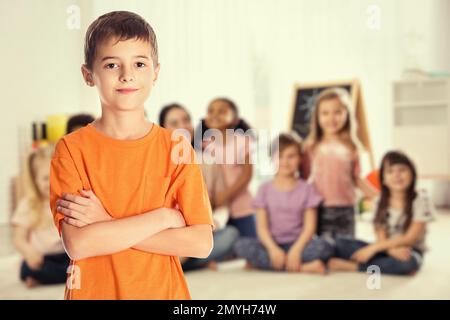 Boy and group of little children with teacher in classroom Stock Photo