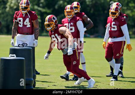 New York Giants running back Saquon Barkley (26) runs past Washington  Redskins outside linebacker Ryan Kerrigan (91) after making a reception in  the first quarter against the Washington Redskins at FedEx Field