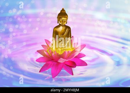 Lotus flower with Buddha figure on water, bokeh effect Stock Photo