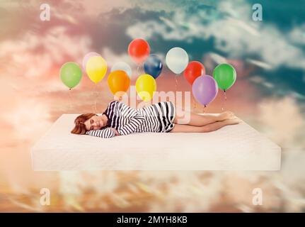 Sweet dreams. Bright cloudy sky with air balloons around sleeping woman Stock Photo
