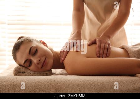 Young woman receiving back massage in spa salon Stock Photo