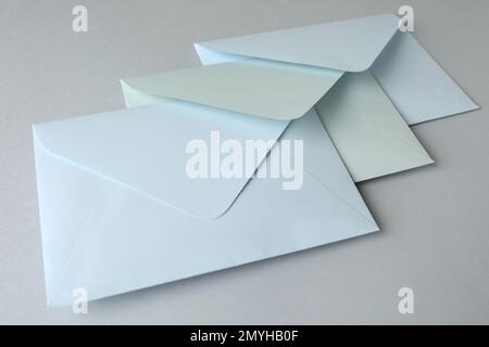 White paper envelopes on light grey background, closeup. Mail service Stock Photo