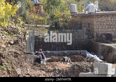 Two men working on the foundation of a house being built in a Northern Iraqi village Stock Photo
