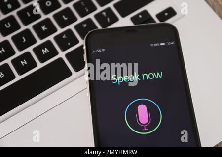 Smartphone with activated voice search app on laptop, closeup Stock Photo