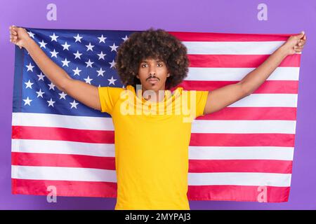Serious african man raising a north america national flag Stock Photo