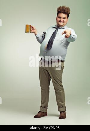 Ive been waiting for you. an overweight man pointing at the camera while holding a pint of beer. Stock Photo