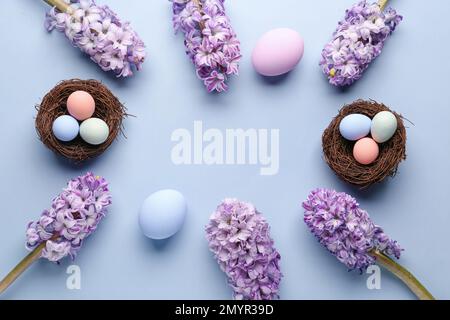 Frame made of beautiful hyacinth flowers and Easter eggs on color background Stock Photo