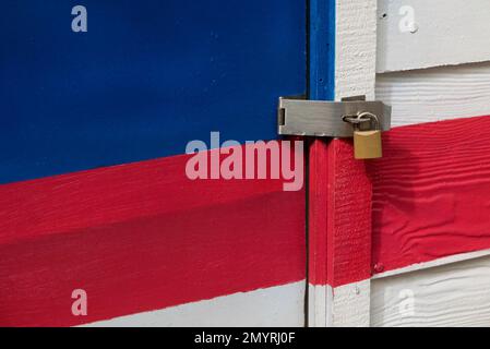 Locked padlock with chain at colorful wooden door. Stock Photo