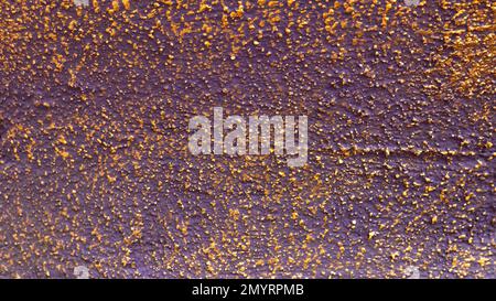 Gold and purple textured surface of a wall. Stock Photo