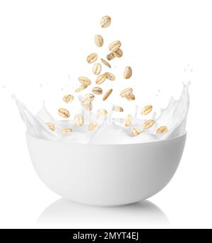 oat flakes falling in bowl with splashing milk isolated on white Stock Photo
