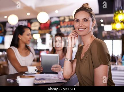Today your office goes with you. A woman smiling at the camera with two of her colleagues in the background. Stock Photo