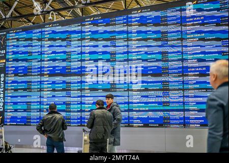 Frankfurt, Germany - February 4, 2023: flight schedule board. travellers standing in front of Flight display schedule in International airport. Close Stock Photo