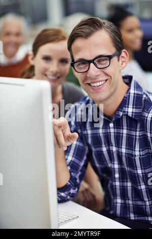 Problem sorted. Portrait of coworkers sitting at computers in an office. Stock Photo