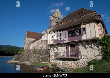 River and medieval church and house, Beaulieu-sur-Dordogne, Corrèze, Nouvelle-Aquitaine, France Stock Photo