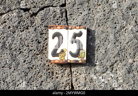 wall made of volcanic stones with house number 25 in Lanzarote, Spain Stock Photo