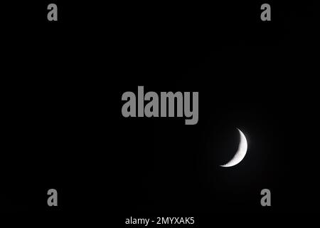 The growing moon with black copy space Stock Photo