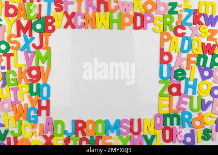 Colorful alphabet magnets on whiteboard making frame for copy space Stock Photo