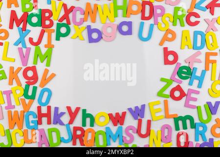 Colorful alphabet magnets on whiteboard making frame for copy space Stock Photo