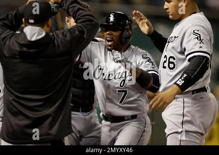 Chicago White Sox's Jimmy Rollins, front, throws his bat after