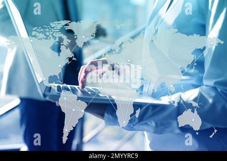 Wholesale and logistics concept. Woman using laptop in office, world map illustration on foreground Stock Photo