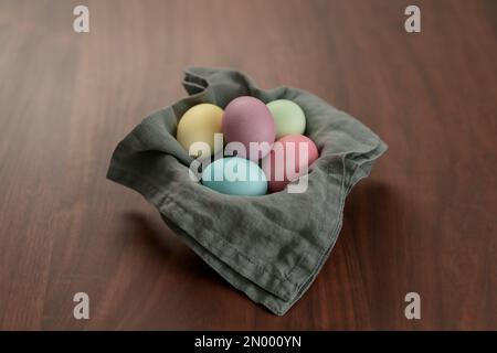 Easter eggs in a bowl with napkin on walnut wood table , shallow focus Stock Photo