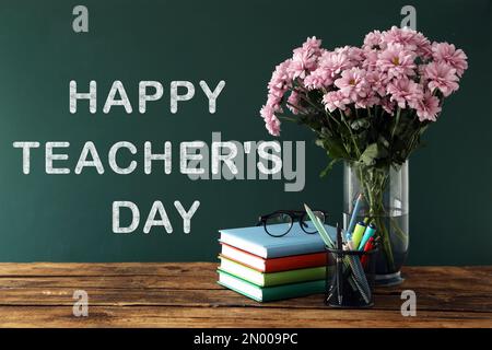 Vase with beautiful chrysanthemum flowers, notebooks and alarm clock on ...