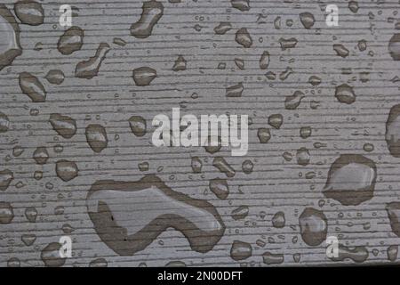 wet wooden planks of bench, background of wood texture with water drops from the rain, autumn mood. Stock Photo