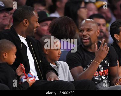 Basketball player Gilbert Arenas, left, talks with Floyd Mayweather, Jr.,  right, during the second half of an NBA basketball game between the Los  Angeles Lakers and the Washington Wizards, Sunday, March 27