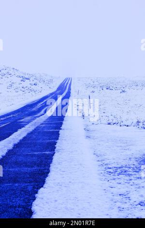 dark lonley road in snow storm Stock Photo