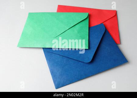 Colorful paper envelopes on light grey background. Mail service Stock Photo