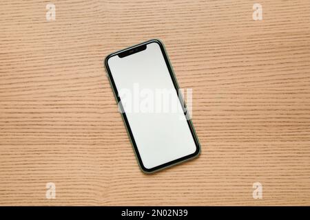 MYKOLAIV, UKRAINE - JULY 07, 2020: iPhone 11 on wooden background, top view. Mockup for design Stock Photo