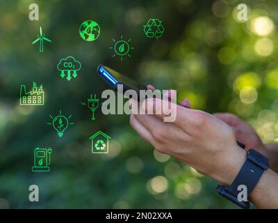 Woman with smartphone in hand and ecology icons around. Alternative energies to save the planet Stock Photo