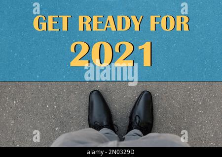 Text Get Ready For 2021 on asphalt in front of man, top view Stock Photo