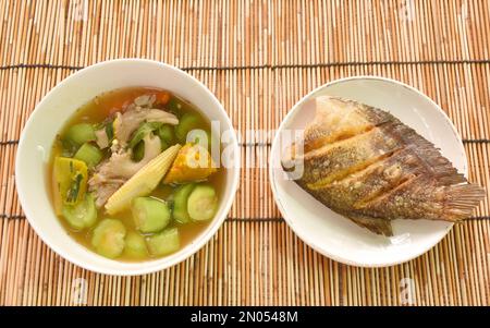 boiled spicy mixed vegetable curry soup on bowl with deep fried snake skin catfish or gourami on dish Stock Photo