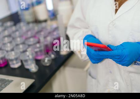 Close-up of a researcher using a phone in a laboratory. Stock Photo