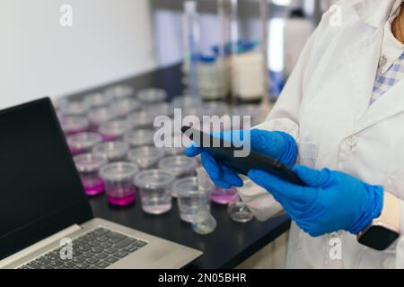 Unrecognizable woman in laboratory typing on a tablet Stock Photo