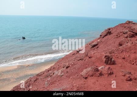 view from red mountains to the red beach and red colored sea of the persian gulf, Hormuz island Stock Photo