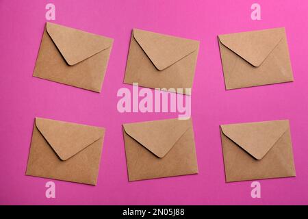 Brown paper envelopes on purple background, flat lay Stock Photo