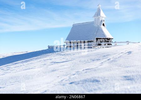Spectacular frozen, covered with fresh snow Chapel of Mary of the Snows on Velika planina Alpine pasture, winter fairytale landscape, Slovenia Stock Photo