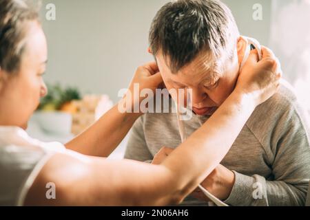 elderly woman with Down syndrome accompanied by an assistantto help her, asian woman Stock Photo