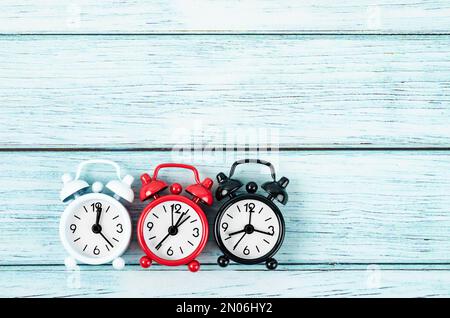 Many different alarm clocks on blue wooden background with copy space for your text or message. Stock Photo