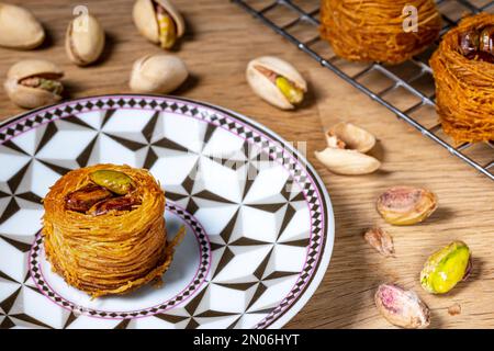 Angel hair nests with caramelized pistachios. Still life decorated with pistachio nuts and more cupcakes on a cooling rack Stock Photo