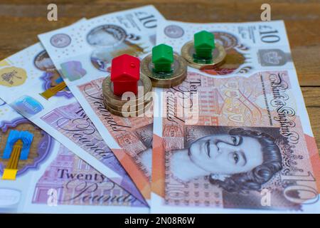 Houses on top of UK currency, a house price and mortgages concept. Stock Photo
