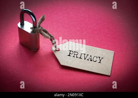 A padlock with number attached to a tag written with Privacy on red background. Stock Photo