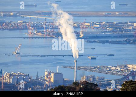 Smoke from chimney and loading cranes at empty industrial port Stock Photo