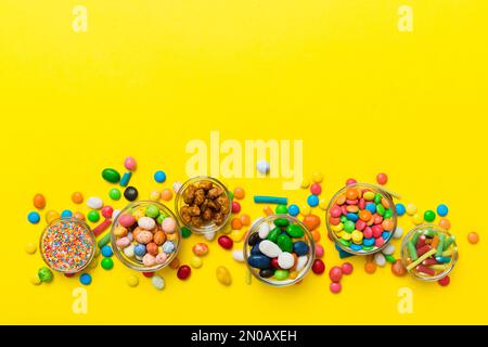 different colored round candy in bowl and jars. Top view of large variety sweets and candies with copy space. Stock Photo